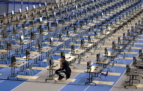 A Louvain-La-Neuve university student sits at a desk while taking an exam at an athletics facility in Louvain-La-Neuve, Belgium, on June 2. Students could choose to take their exams from home or in this hall. 