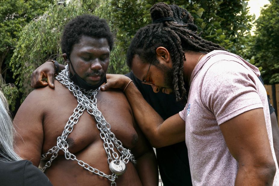 Buffalo Bills cornerback Josh Norman prays over Malcolm Rutledge during protests near the White House on June 9. "Both White and Black people haven't seen a Black man in chains in years," Rutledge said. "They don't understand the psychological chains we still carry."