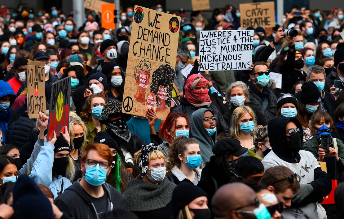 People hold up placards at a Black Lives Matter protest to express solidarity with US protestors in Melbourne on June 6, 2020.