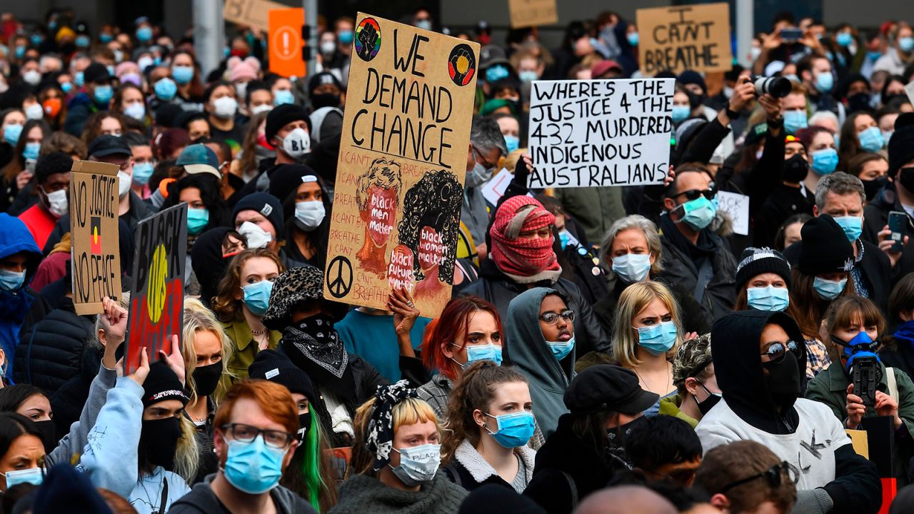 People hold up placards at a Black Lives Matter protest to express solidarity with US protestors in Melbourne on June 6, 2020.