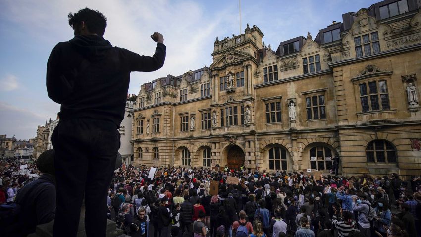 OXFORD, ENGLAND - JUNE 09: Demonstrators gather outside University of Oxford's Oriel College during a protest called by the Rhodes Must Fall campaign on June 09, 2020 in Oxford, England. The Rhodes Must Fall campaign protests outside University of Oxford's Oriel College where a statue of imperialist Cecil John Rhodes looks out over the High Street and the college's front door. Cecil Rhodes was a British businessman and politician in South Africa, who served as Prime Minister of the Cape Colony from 1890 to 1896.  (Photo by Christopher Furlong/Getty Images)
