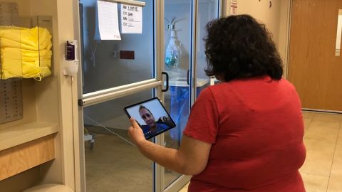 Chaplain Melinda Plumley can't visit coronavirus patients in their rooms and uses an iPad to communicate remotely.