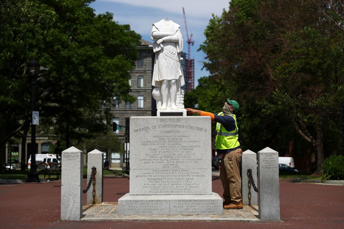 A parks worker inspects a statue of Christopher Columbus that had its head removed at Christopher Columbus Waterfront Park on June 10 in Boston, Massachusetts.