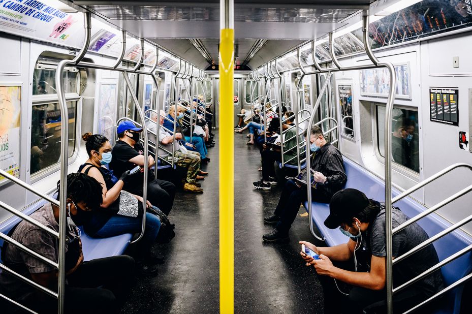 Commuters wear protective masks as they ride a subway train in New York on June 8.