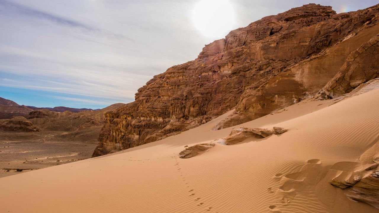<strong>Open desert:</strong> Visitors must take a short trek up this huge sand dune to reach the impressive rock formation.