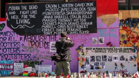 A man takes photos of a makeshift memorial in the so-called "Capitol Hill Autonomous Zone" in Seattle.