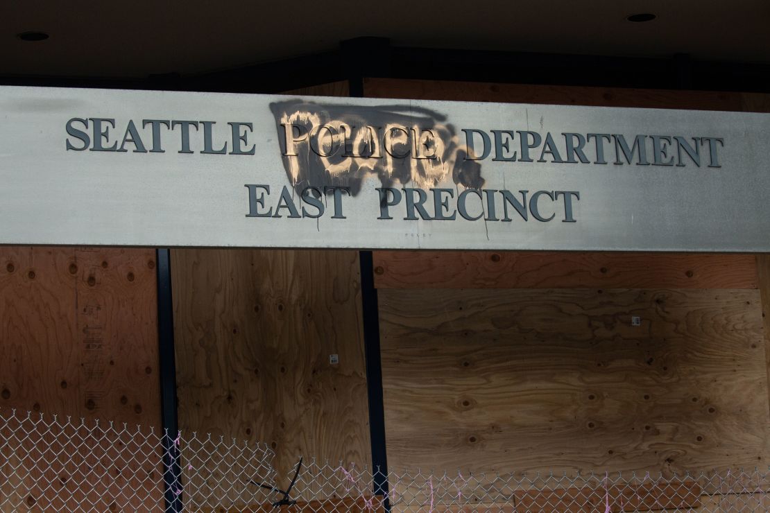 A defaced sign for the East Precinct reads "Seattle People Department" on Wednesday in Seattle.