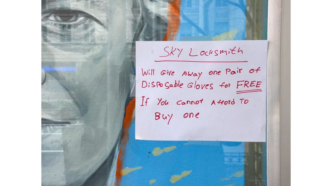 A sign appears in a locksmith's window offering a free pair of disposable gloves to anyone who can't afford it in New York City