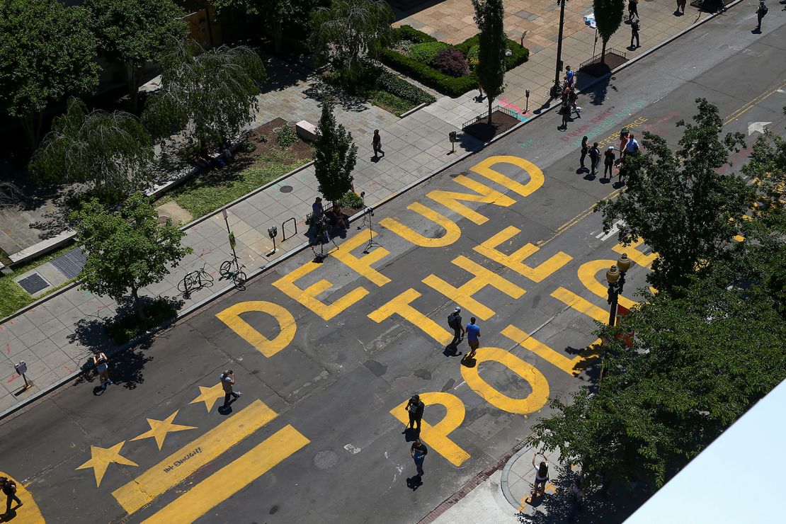 People walk down 16th street after "Defund The Police" was painted on the street near the White House.