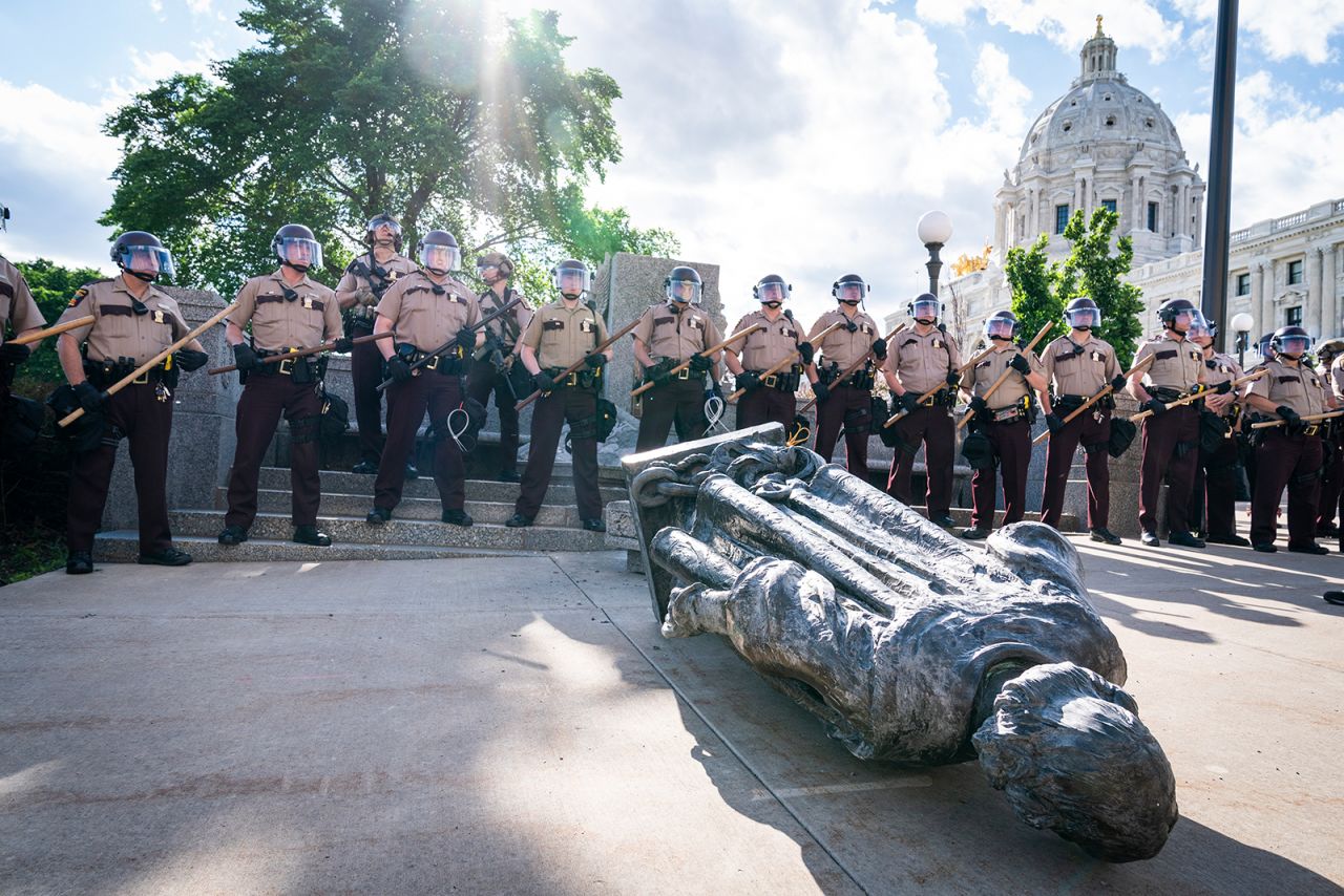 Minnesota state troopers surround a statue of Christopher Columbus after activists pulled it down in front of the Capitol in St. Paul on Wednesday, June 10. Columbus statues are being taken down and tampered with —and many Confederate statues, too — as <a href="https://www.cnn.com/2020/06/10/us/christopher-columbus-statues-down-trnd/index.html" target="_blank">a racial reckoning occurs</a> following the death of George Floyd. Columbus has long been a contentious figure in history for his treatment of the Indigenous communities he encountered and for his role in the violent colonization at their expense.