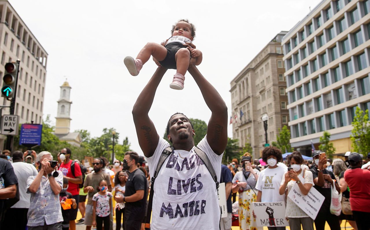 A man holds up a child during a protest in Washington on Saturday, June 6.