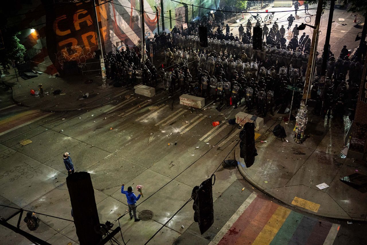 A person holds flowers as demonstrators clash with police in Seattle on Sunday, June 7.