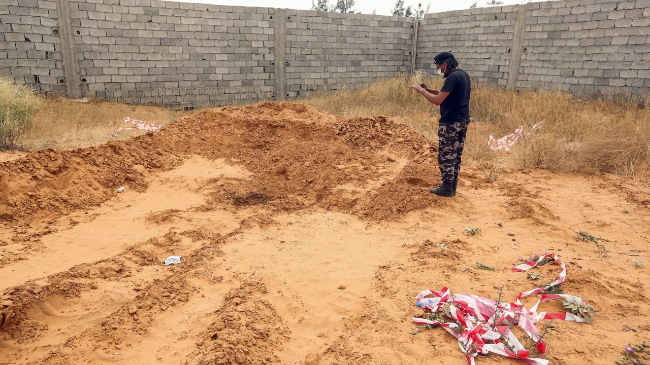 A member of security forces affiliated with the Libyan Government of National Accord (GNA)'s Interior Ministry takes a picture as he stands at the reported site of a mass grave in the town of Tarhuna, about 65 kilometres southeast of the capital Tripoli on June 11, 2020. 