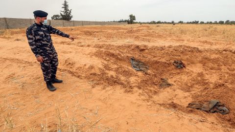 A member of security forces affiliated with the Libyan Government of National Accord (GNA)'s Interior Ministry points at the reported site of a mass grave in the town of Tarhuna, about 65 kilometres southeast of the capital Tripoli on June 11, 2020. 
