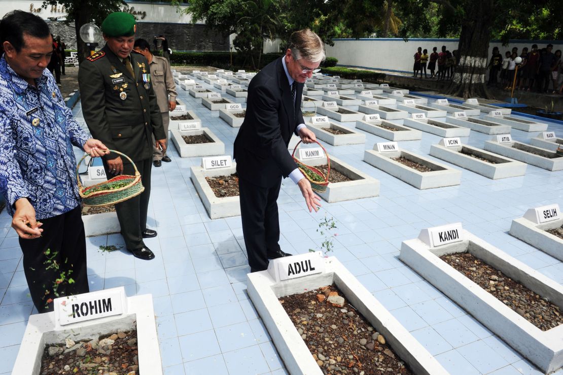 Former Dutch Ambassador to Indonesia Tjeerd de Zwaan, center, leaves flowers at the graves of victims of a 1947 massacre, in Rawagede, Indonesia, on December 9, 2011, when the Netherlands made a formal apology.