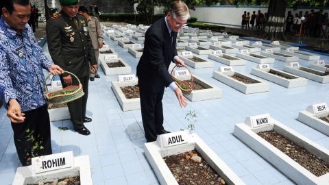 Former Dutch Ambassador to Indonesia Tjeerd de Zwaan, center, leaves flowers at the graves of victims of a 1947 massacre, in Rawagede, Indonesia, on December 9, 2011, when the Netherlands made a formal apology. 