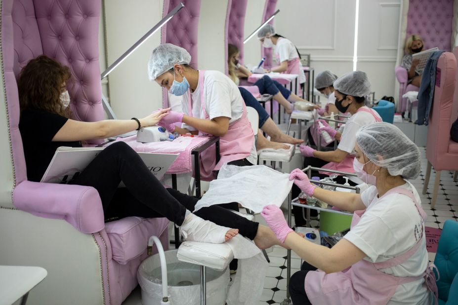 Nail technicians perform manicures and pedicures at a nail bar in Moscow on June 9. The Russian capital ended a tight lockdown that had been in place since late March.
