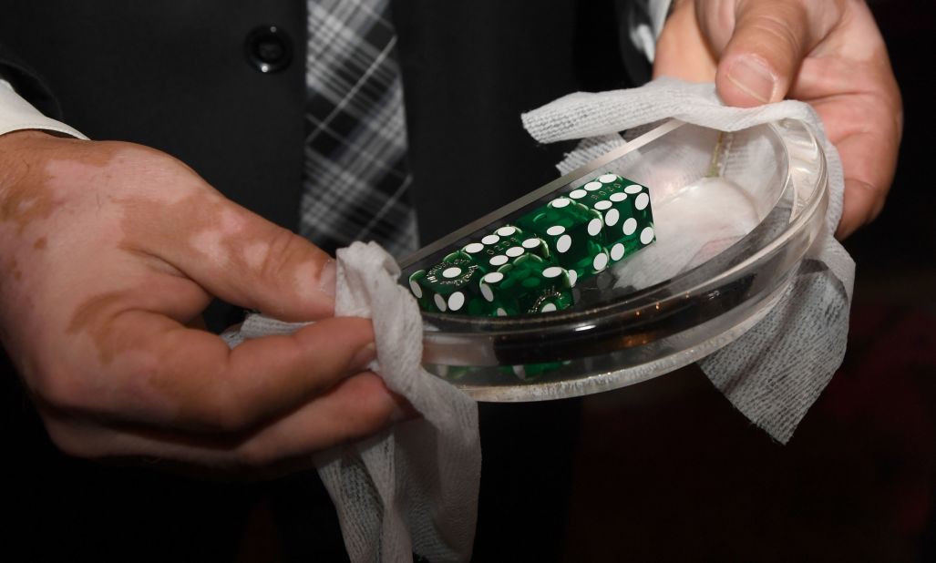 Floor supervisor Dumitru Carabasu sanitizes dice at Las Vegas' Excalibur Hotel & Casino on June 11. It was reopening for the first time since mid-March.