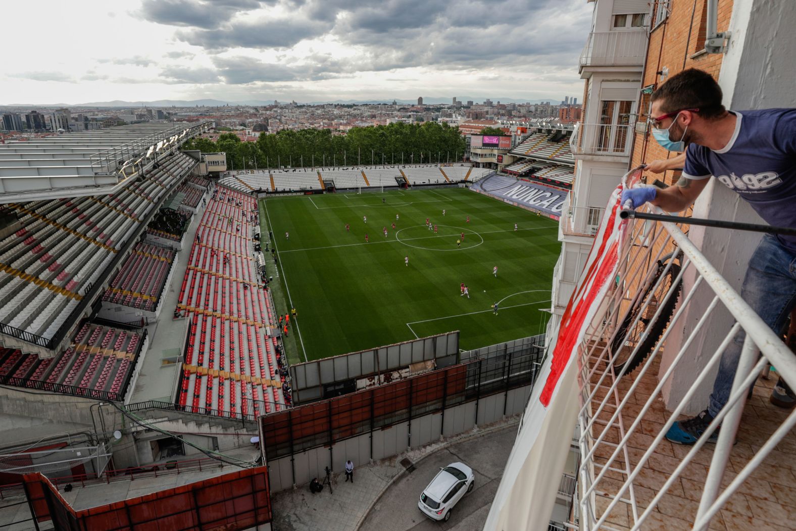 A soccer fan in Madrid watches a professional match between Rayo Vallecano and Albacete on June 10. Spanish leagues resumed more than three months after play was suspended because of the pandemic.
