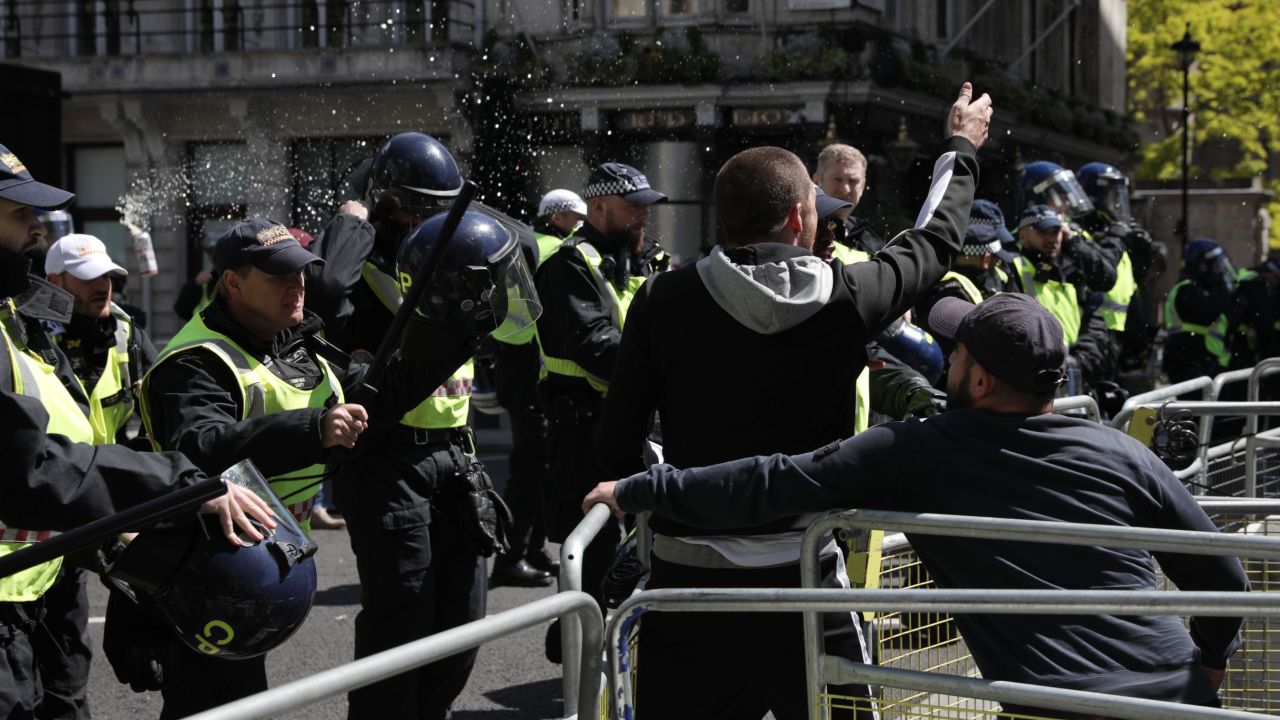 A can of beer is thrown at police officers as activists from far-right linked groups clash with police on Parliament Street as far-right groups gathered to "protect" statues in London.