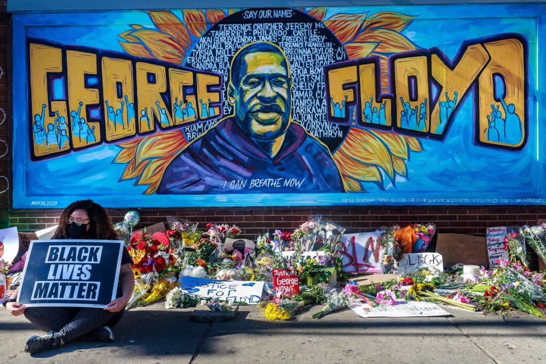Flowers, signs and balloons are left at a makeshift memorial to George Floyd near the spot where he died.