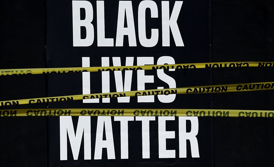 A "Black Lives Matter" placard is seen behind caution tape during a peaceful protest in Washington against police brutality and the death of George Floyd.