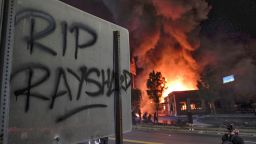 A Wendy's restaurant, background, burns Saturday, June 13, 2020, in Atlanta after demonstrators set it on fire. Demonstrators were protesting the death of Rayshard Brooks, a black man who was shot and killed by Atlanta police Friday evening following a struggle in the Wendy's drive-thru line. (Ben GrayAtlanta Journal-Constitution via AP)