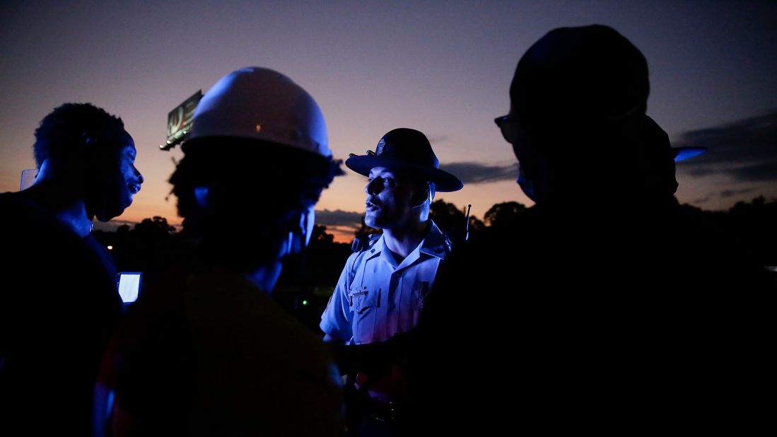 A police officer talks to protesters on an Atlanta highway, near where Brooks was killed. A major interstate was shut down after protesters marched onto a connector and were met by lined-up police vehicles.