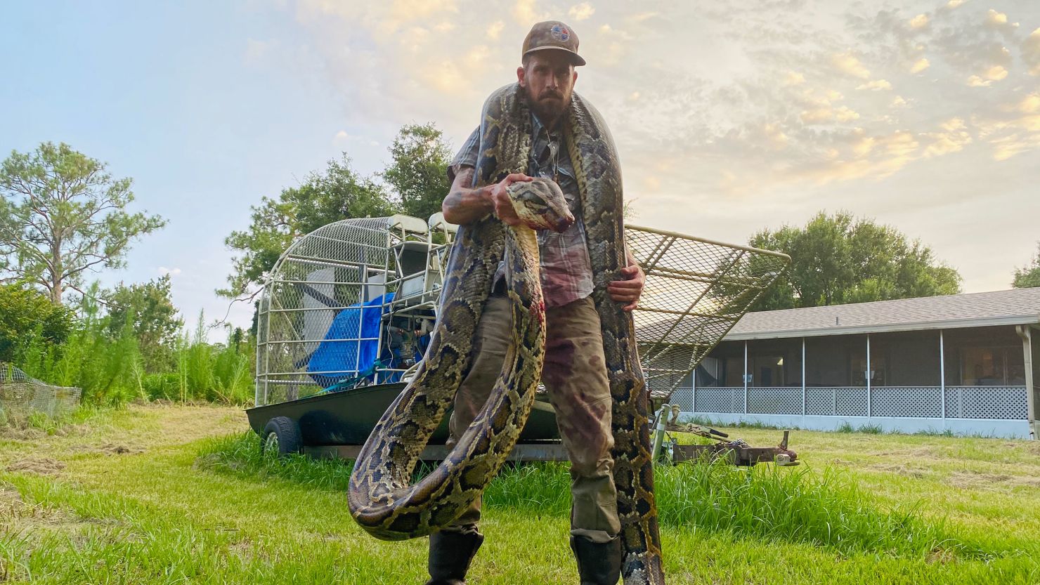 Mike Kimmel with the 17-foot python he caught draped around his neck. 