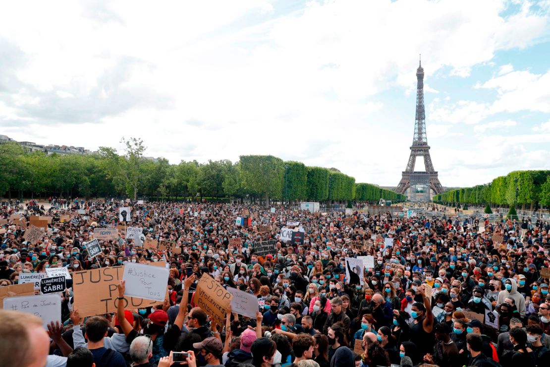 A protester holds a banner on Champ de Mars, in Paris on June 6, 2020, as part of  Black Lives Matter protests in the city.