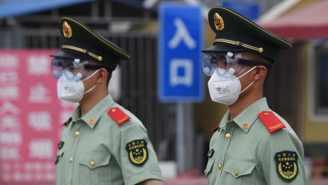 Paramilitary police officers wear face masks and goggles as they stand guard at an entrance to the closed Xinfadi market in Beijing on June 13.
