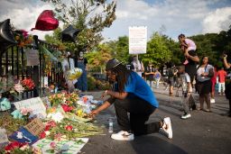 A man kneels at the memorial for Rayshard Brooks on June 14 at the Wendy's restaurant where Brooks was shot two days earlier.