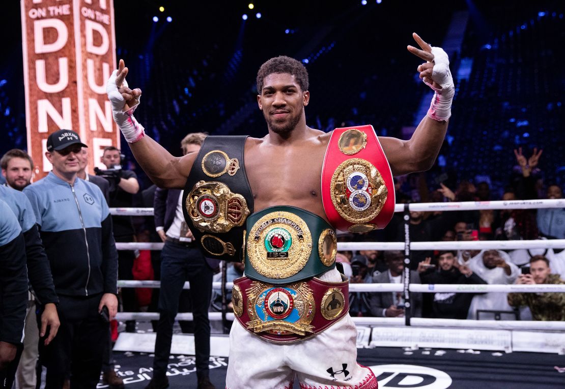 Joshua poses for a photo with the IBF, WBA, WBO & IBO World heavyweight title belts after beating Andy Ruiz Jr.