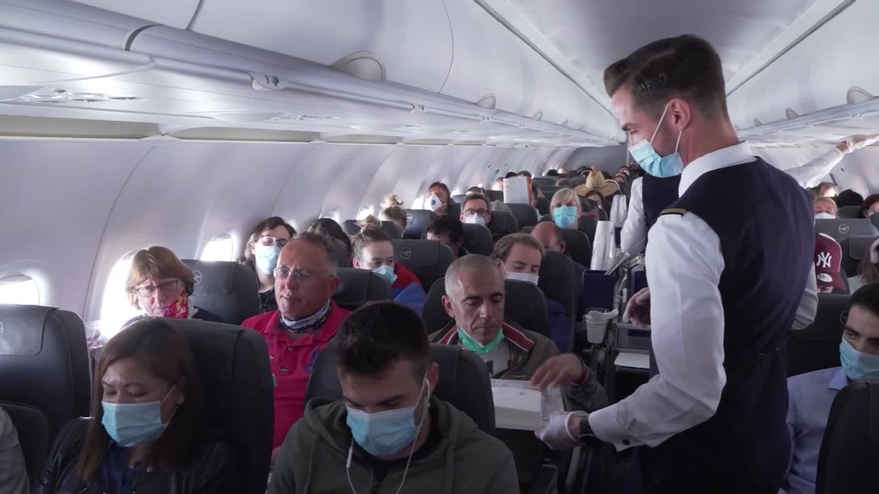 Cabin crew handed passengers sanitizing wipes.