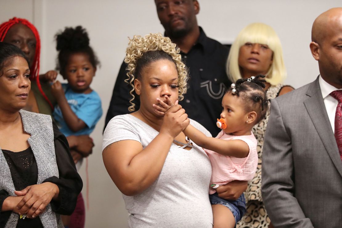 Rayshard Brooks' widow Tomika Miller holds their 2-year-old daughter Memory at a press conference.