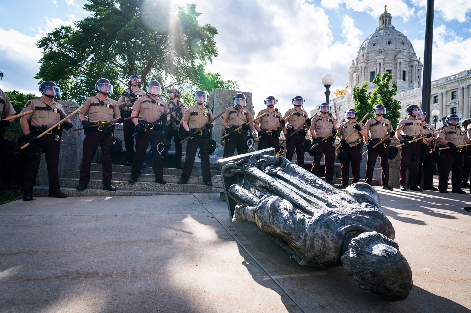 Minnesota state troopers surround a statue of Christopher Columbus after activists pulled it down in front of the Capitol in St. Paul on June 10. <a href="index.php?page=&url=https%3A%2F%2Fwww.cnn.com%2F2020%2F06%2F10%2Fus%2Fchristopher-columbus-statues-down-trnd%2Findex.html" target="_blank">Columbus has long been a contentious figure in history</a> for his treatment of the Indigenous communities he encountered and for his role in the violent colonization at their expense. 