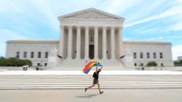 Joseph Fons holding a Pride Flag, runs in front of the U.S. Supreme Court building after the court ruled that a federal law banning workplace discrimination also covers sexual orientation, in Washington, June 15, 2020.