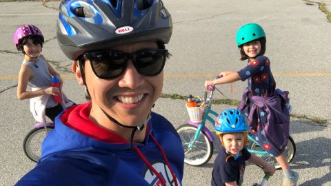 Steve Dypiangco, with (from left) daughters Miriam, 9, and Jane, 8, and son Ignatius "Nate," 3, take a break from a bike ride in an empty parking lot. 