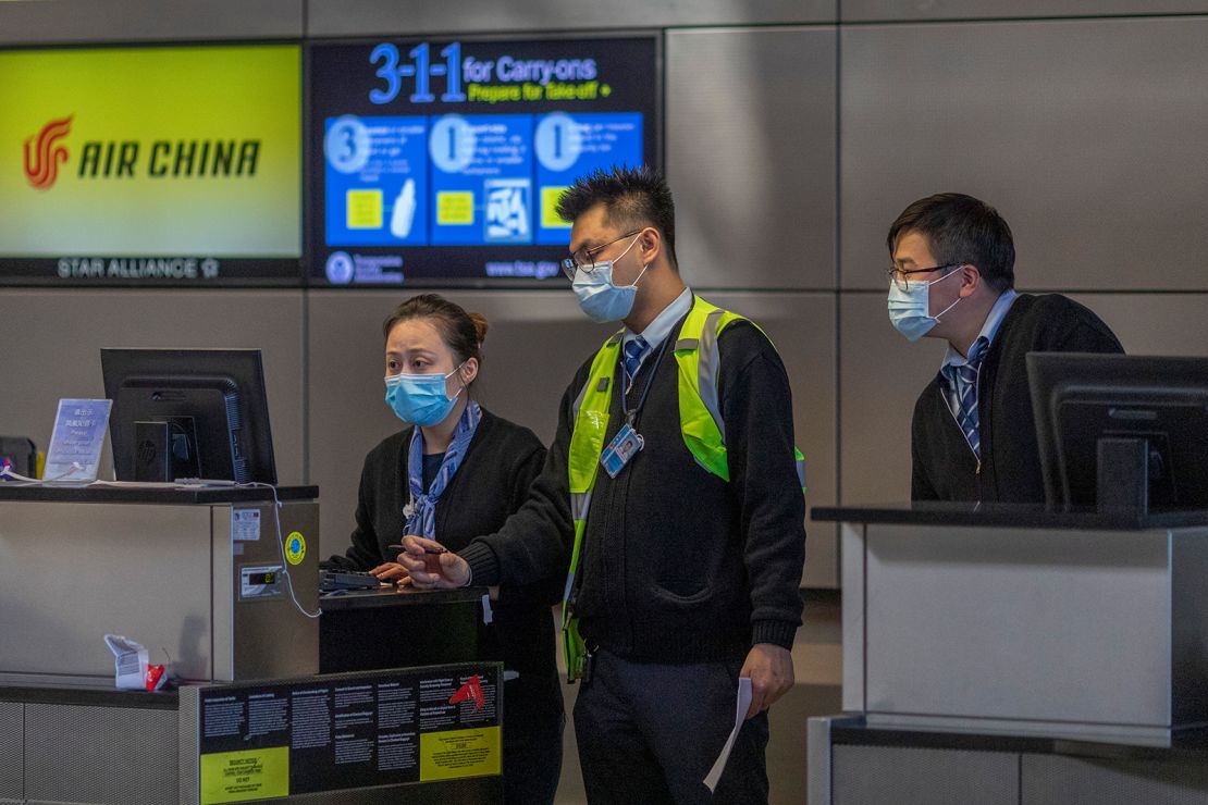 Air China employees wear medical masks at LAX Tom Bradley International Terminal on February 2, in Los Angeles, California. 