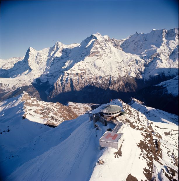 <strong>Piz Gloria, "On Her Majesty's Secret Service" (1969) -- </strong>Blofeld's mountain-top brainwashing facility is a strange intermingling of life and art. Location scout Hubert Fröhlich discovered an in-construction restaurant nearly 3,000 meters up Mount Schilthorn, Switzerland with spectacular 360-degree views and adaptable circular shape. The producers were so taken by it they <a href="https://schilthorn.ch/cmsfiles/Schilthornbahn_50%20Jahre%20OHMSS_e_1.pdf" target="_blank" target="_blank">helped finance the completion of the building</a> to make it usable, including interior fixtures and fittings, and constructed a heliport. Crew descended on nearby town Mürren, and at one point reportedly had to helicopter in snow from a nearby glacier to cover the unseasonably bare mountain peak. Once filming completed the restaurant opened, but retained Fleming's name for Blofeld's retreat, Piz Gloria, along with many of the film set's fittings. 