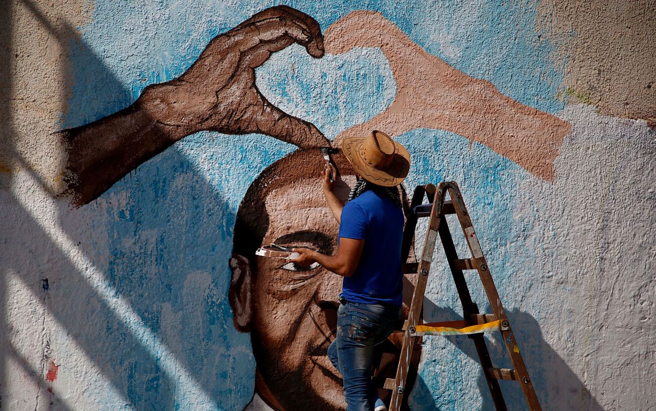 An artist paints a Floyd mural in Gaza City on June 16.