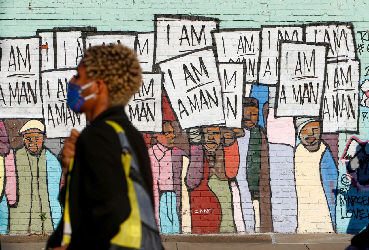 Protesters pass a mural in Memphis, Tennessee, on May 31. It was painted by Marcellous Lovelace.