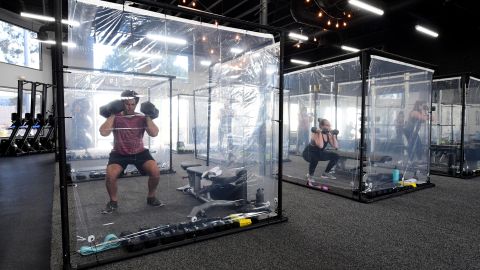 People exercise at Inspire South Bay Fitness behind plastic sheets in their workout pods on June 15 in Redondo Beach, California.
