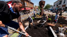 MINNEAPOLIS, MN - JUNE 17: Members of Spark-Y, a nonprofit youth empowerment group, shovel soil while building a garden in the memorial site for George Floyd at the intersection of 38th Street and Chicago Avenue on June 17, 2020 in Minneapolis, Minnesota. The memorial site where George Floyd was killed by members of the Minneapolis Police Department, has become an ever changing place for art projects, food donations, and community meeting. (Photo by Stephen Maturen/Getty Images)