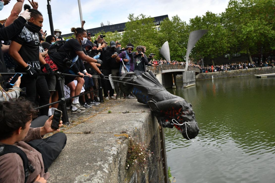 Protesters throw a statue of Edward Colston into a nearby river during a Black Lives Matter protest.