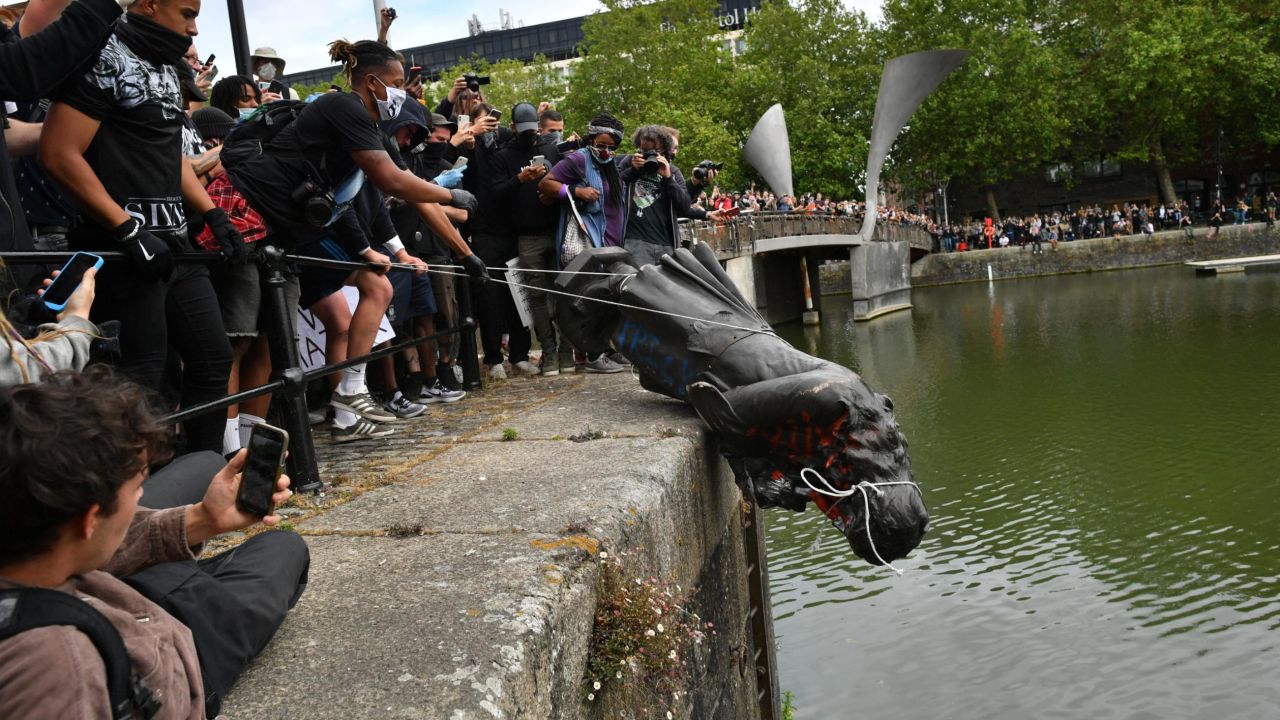 Protesters throw a statue of Edward Colston into a nearby river during a Black Lives Matter protest.