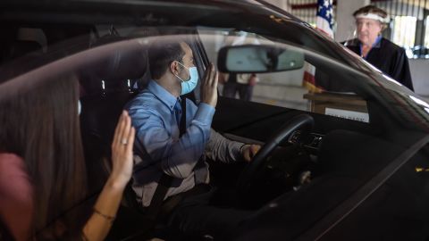 Charbel Abdo Habib of Rochester Hills and his wife Rana El-hachem, originally from Lebanon, raise their hands as Federal Magistrate Judge Patricia Morris of Bay City swears them in as new citizens individually from a podium during a drive-thru service in a parking structure at the US Citizenship and Immigration Services headquarters on Detroit's east side on Wednesday, June 17, 2020.