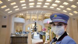 An employee wearing a uniform and a face mask waits in the entrance hall of Berlin's famous Hotel Adlon Kempinski. 