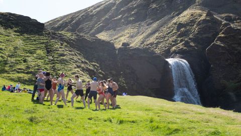 A group of Polish visitors enjoy a waterfall near Reykjavik.