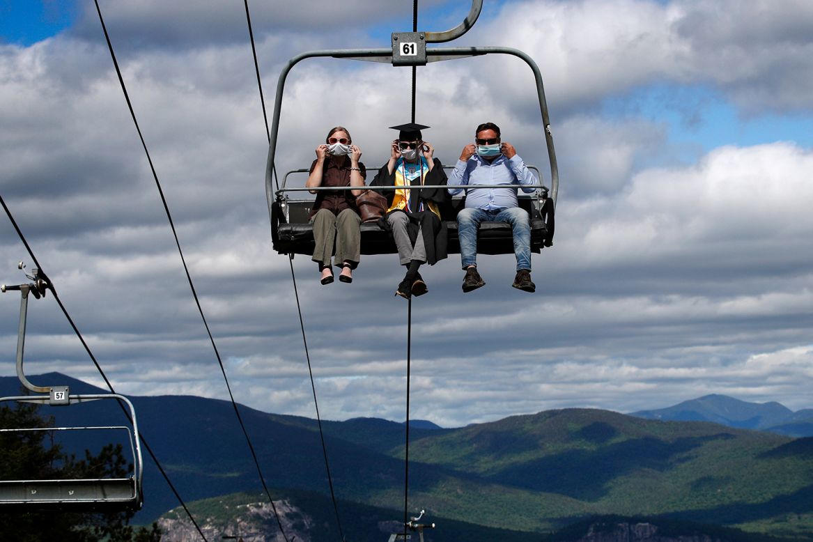 Kennett High School graduate Cole Bradley and his parents adjust their masks as they ride a chairlift to receive his diploma in North Conway, New Hampshire, on Saturday, June 13. The school's unique commencement ceremony was created to adhere to social-distancing guidelines.